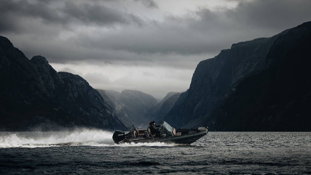 Airborne 7 RIB starboard side driving fast with Fjords in background