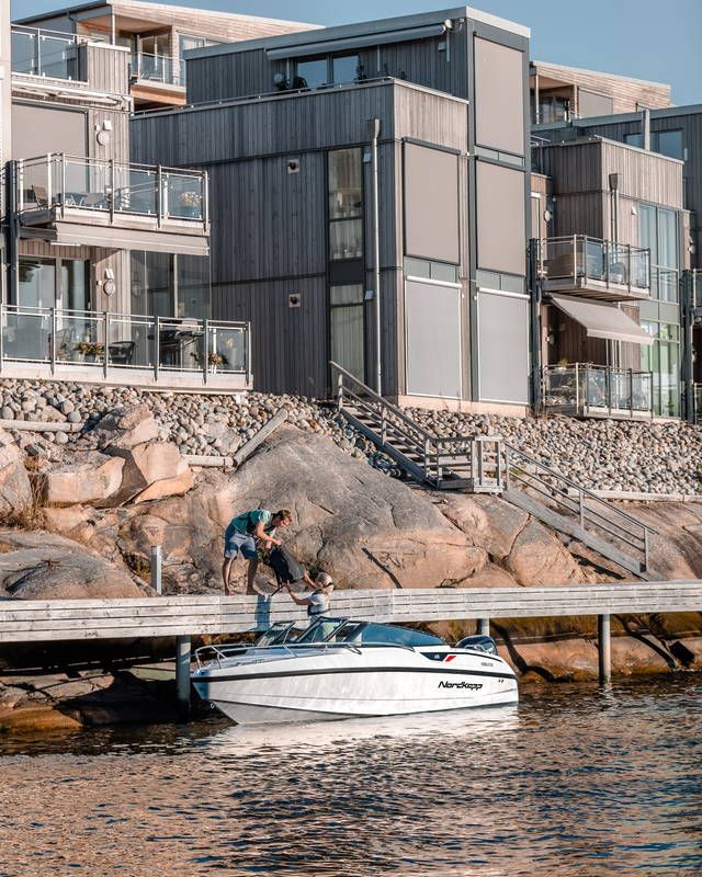 Nordkapp Noblesse 605 on the water next to city buildings