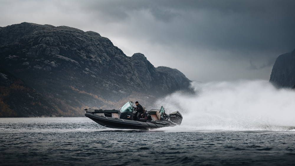 Airborne 7 RIB port side driving fast with Fjords in background