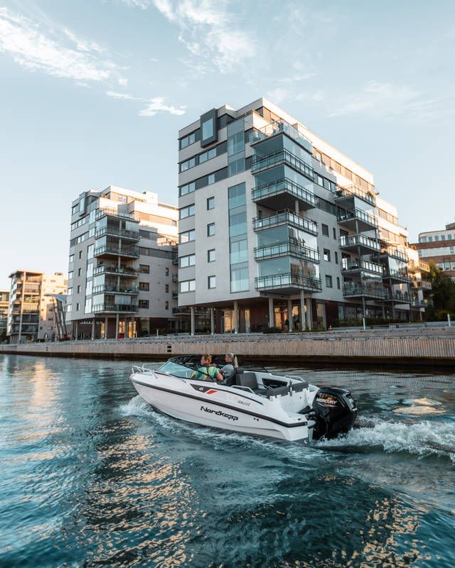 Nordkapp Noblesse 605 on the water next to city buildings